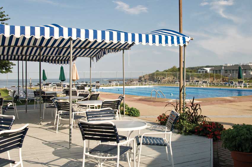 Outdoor dining area by the pool. Utility pole in image.